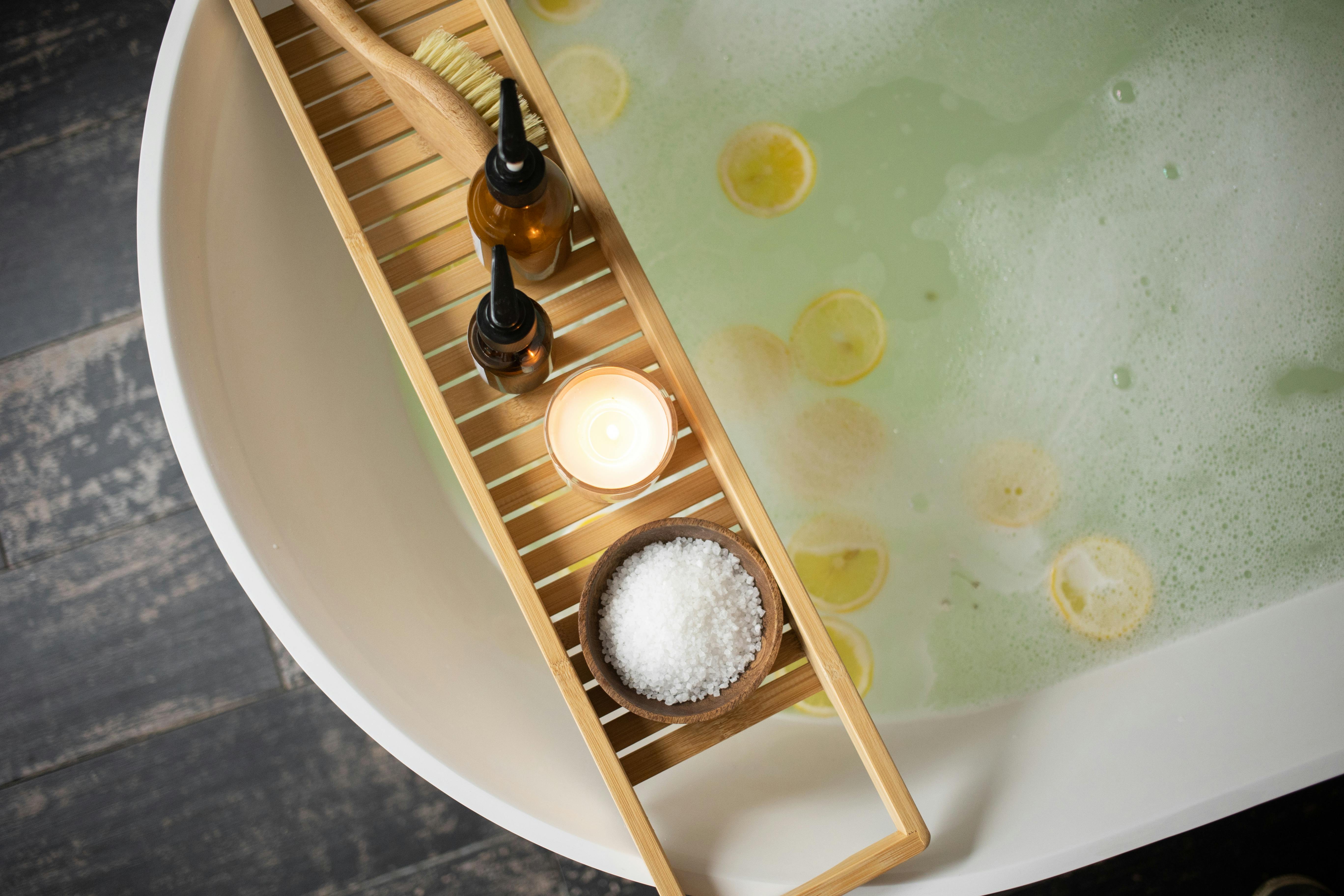 A serene spa setting featuring a close-up view of a white bathtub filled with bubbly water and floating lemon slices.